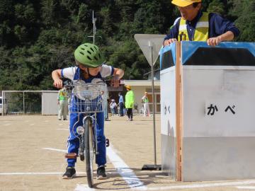 壁の死角をそっと覗いている児童