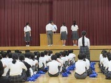 体育館の舞台で表彰状を受け取る生徒たちの様子