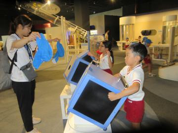 館内で見学する5歳児が空気砲の実験をする様子