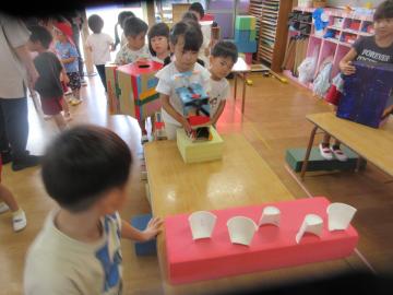 室内で空気砲で的あてをする園児たちの様子