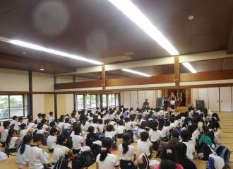 広い畳の部屋の中で、前を向いて話を聞くたくさんの子どもたちの様子。