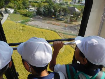 ロープウェイの窓から下の風景を眺める児童の様子。