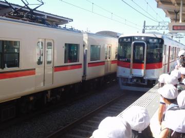 駅のホームで到着する電車を見る子どもたちの様子。