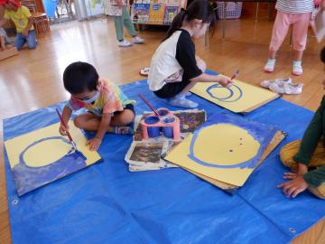 お月さまの絵をかく幼児