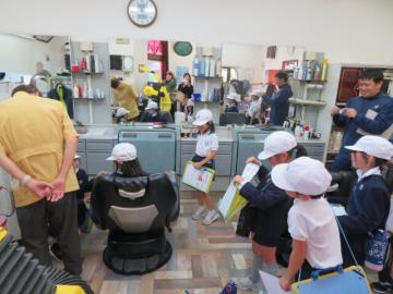 散髪屋さんでリクライニングチェアを操作する2年生