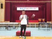 体育館で児童が開会挨拶をする様子