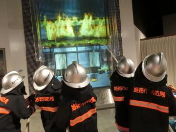 消防服を着て、消火活動体験をしているところ