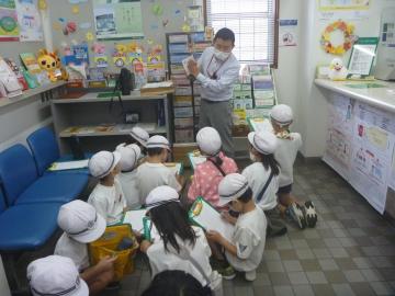 2年生の子どもたちが郵便局で職員の方の話を聞く様子