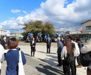 屋外で生徒と教師が出発式の挨拶をする様子