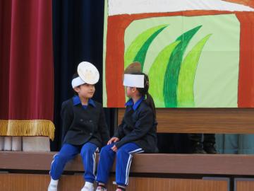 体育館の壇上でお手がみの劇をする児童の様子