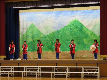 体育館の壇上で安富北小学校伝統の傘踊りを発表する児童たちの様子