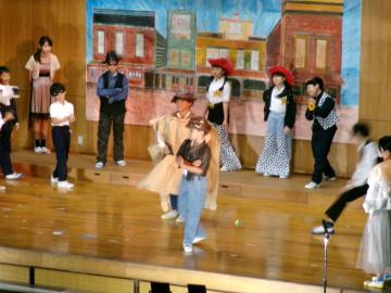 体育館の壇上で、5年生と6年生が迫真の演技をしている様子