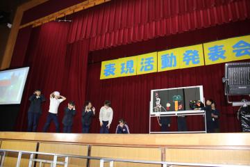 体育館の壇上で、児童たちがおばけを怖がっている様子