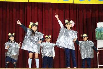 体育館の壇上で児童たちがねずみに仮装している様子