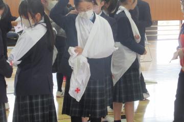 二人組で三角巾を使って救急法を実践している様子