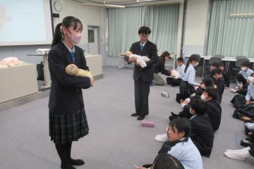 7年生が赤ちゃん抱っこ体験をしている様子