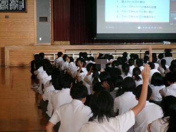 体育館で、法務局人権擁護委員の方の質問に生徒が手を挙げて答えている様子