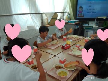 小学校の教室で小学生に囲まれて給食を食べる園児たちの様子