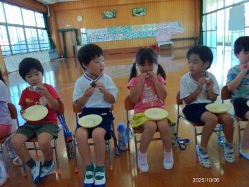 遊戯室でお月見団子を食べる園児たちの様子