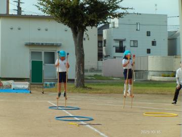 園庭で竹馬で歩く園児たちの様子
