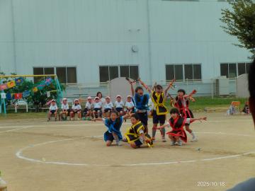 園庭で鳴子を持って踊る園児たちの様子