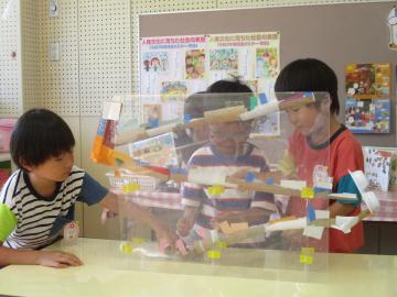 室内でどんぐりを転がして遊ぶ園児たちの様子