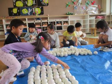 室内で玉入れの球を片付ける園児たちの様子