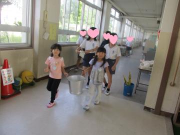 校舎内で給食の鍋を運ぶ園児たちの様子