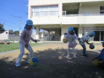 園庭でボール付きをする園児たちの様子