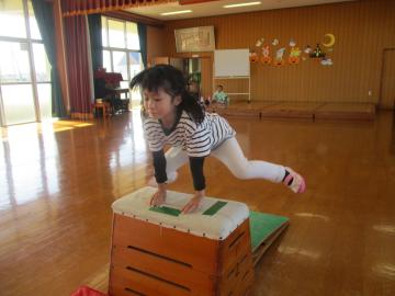 遊戯室で4段の跳び箱を跳ぶ園児たちの様子