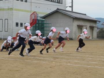 校庭で低学年徒競走のスタートをした児童たちの様子