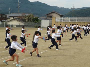 校庭で低学年の児童がダンスを踊る様子
