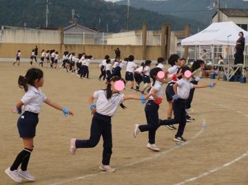 校庭のトラック上で低学年がダンスを踊っている様子