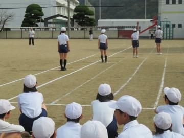 高学年の児童がトラック上で徒競走選手紹介を受ける様子