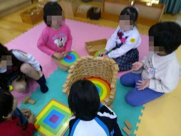 室内でグループで話し合いながら積木を作る園児たちの様子
