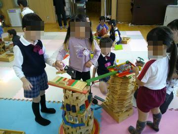 室内で次々と積みあがっている遊具を見る園児たちの様子