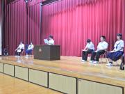 体育館の舞台上で児童が弁論をしている様子