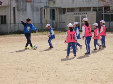 校庭で選手と協力してプレーをする児童たちの様子