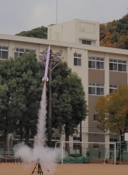 運動場の中央でロケットが飛ぶ様子