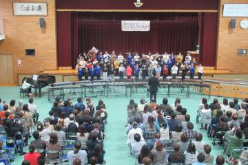 体育館の壇上で、3年生がリコーダーを演奏している様子