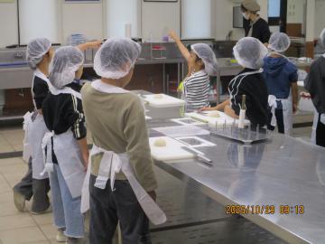 工場内でちくわ作りを体験している児童たちの様子