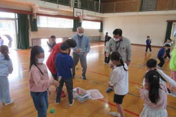 体育館で児童が老人クラブの方と一緒にけん玉をしている様子