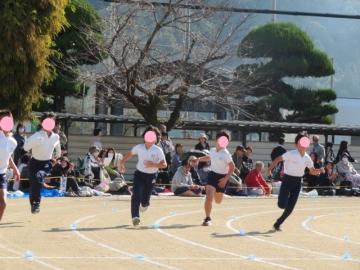 校庭で3年生が80メートル走をする様子