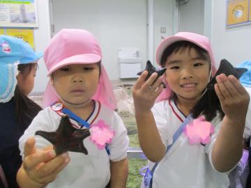 タッチプールでヒトデをつかみ、こちらへ見せる子供