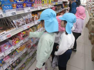 店内で陳列棚からお菓子を選ぶ園児たちの様子