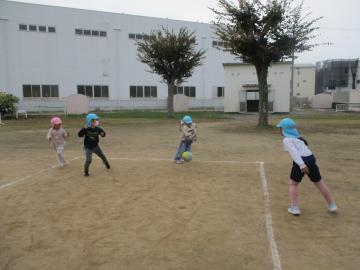 グラウンドで、中当てをして友達にボールを当てている園児たちの様子