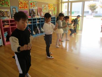 遊戯室内で真剣な表情でけん玉のろうそくの技に挑戦する園児たちの様子