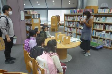 図書館内で司書の方から説明を聞く児童の様子