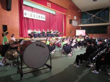 体育館の壇上で吹奏楽部が演奏する様子