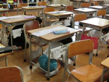 シェイクアウト訓練をする児童